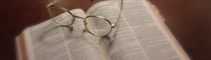 Eyeglasses resting on an open Bible